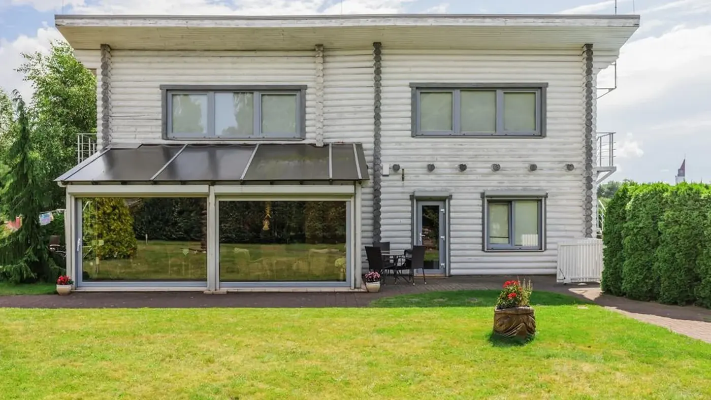 Apartamentų pastato fasadas tarp žalumos Šventojoje